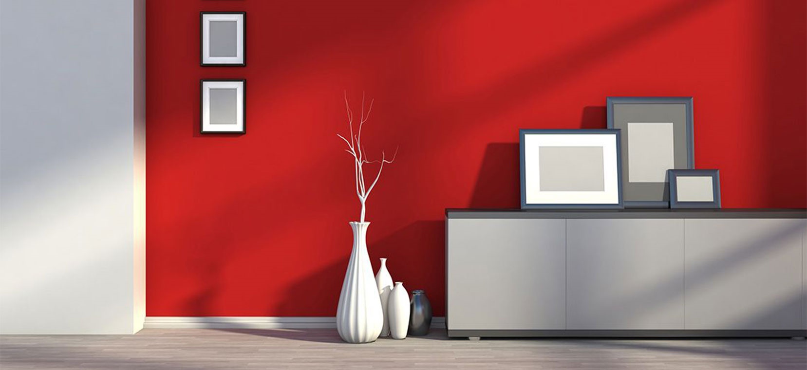 Stylish interior wall in red and gray tones with decorative white vases and empty picture frames