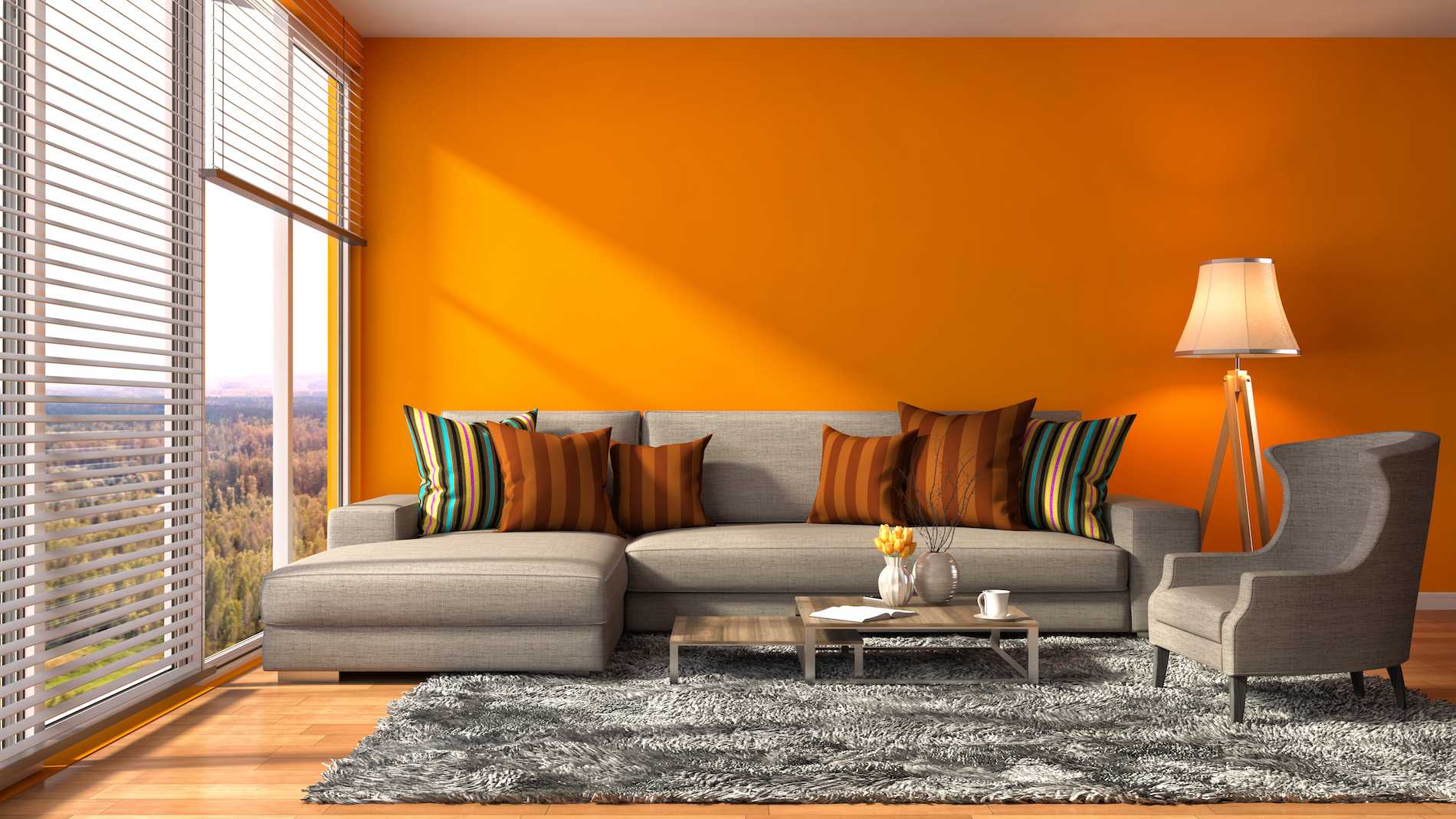 Bright modern living room with orange accent wall and comfortable gray sectional sofa, warm and inviting atmosphere